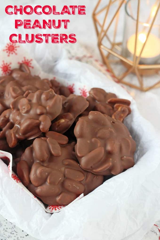Chocolate Peanut Clusters served in a dish with parchment paper and a Christmas star themed napkin.