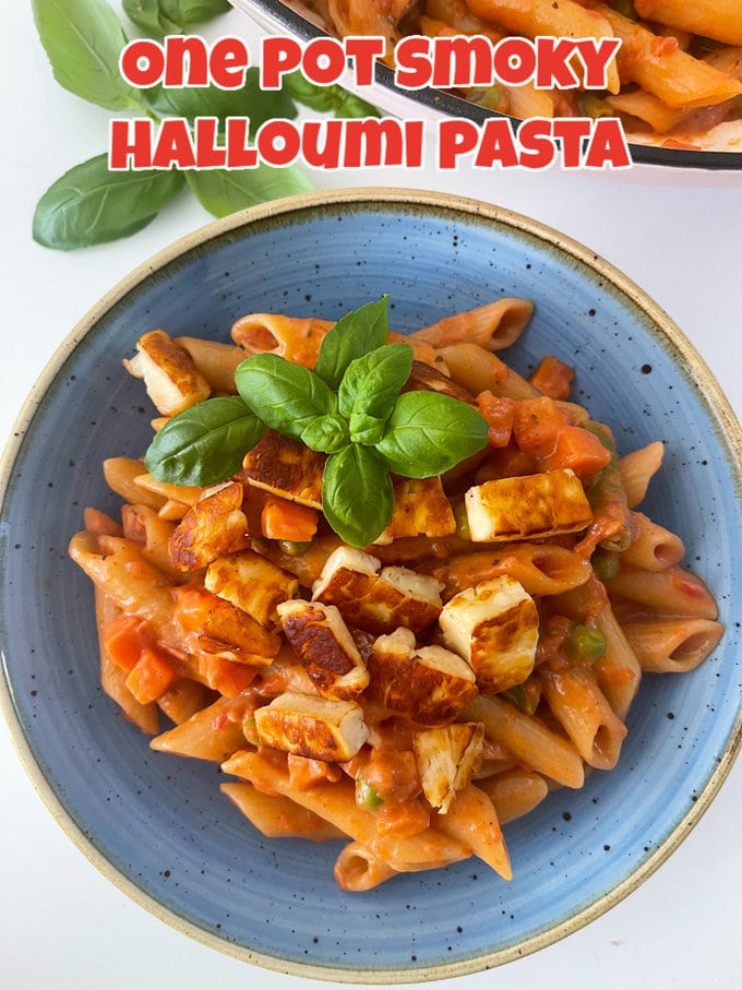 One pot smoky Halloumi pasta, served in a blue pasta bowl and garnished with basil leaves.